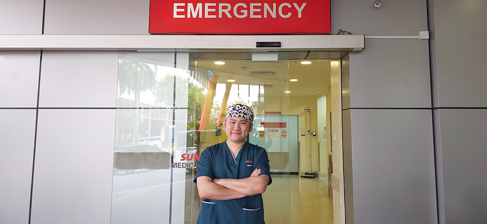 Dr Lim Jinn Yih, Resident Medical Officer in Malaysia standing in front of the accident and emergency room at Sunway Medical Centre.