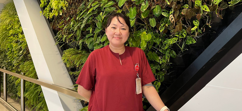 Teh Sim Sze, Deputy Nurse Manager, standing and smiling at the camera